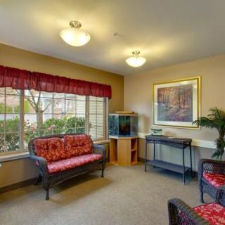 A cozy living room with sofas, a fish tank, and large windows offering natural light.