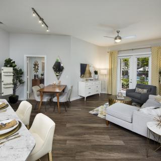 A modern living room with a dining area, featuring stylish furniture and ample natural light.