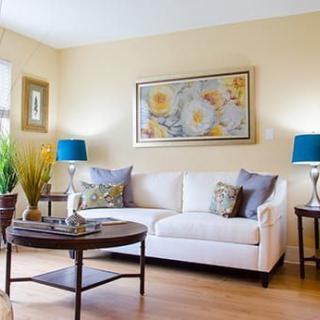 A cozy living room with a white sofa, colorful cushions, and vibrant decor.
