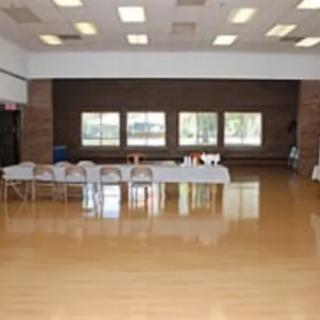 An empty room with tables and chairs set up near the windows.