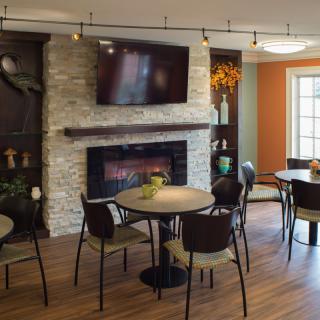 A cozy living room with a fireplace, modern decor, and a dining area.