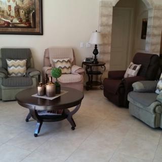 A cozy living room with comfortable chairs and a central coffee table.