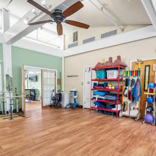 A spacious interior designed for exercise and rehabilitation, featuring fitness equipment and a welcoming atmosphere.
