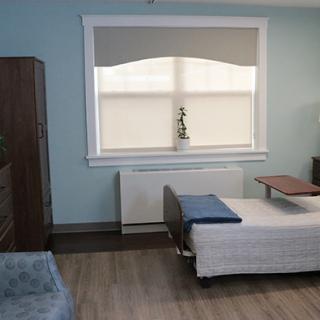 A clean, modern hospital room with a single medical bed and large window.