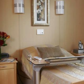 A serene spa room featuring a massage table, flower arrangement, and calming decor.