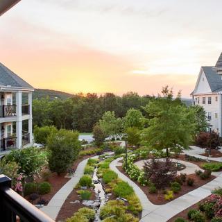 A beautiful residential garden with pathways, surrounded by buildings at sunset.