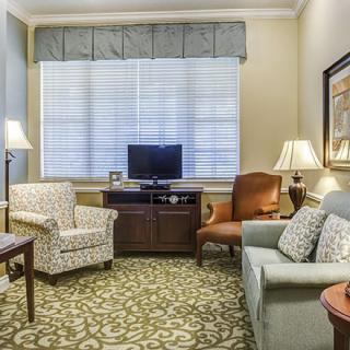 A cozy living room with comfortable seating, a small television, and decorative elements.
