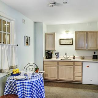 Cozy kitchen with a checkered tablecloth and wooden cabinets.