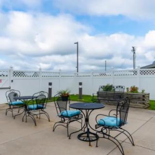 A cozy outdoor patio area with tables and chairs under a partially cloudy sky.