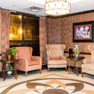 A cozy living room with armchairs, warm lighting, and decorative elements.
