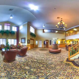 Spacious hotel lobby with elegant furnishings and a chandelier.