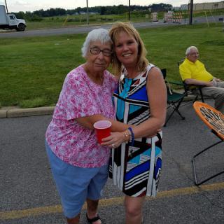 A joyful moment shared between two friends at an outdoor gathering.