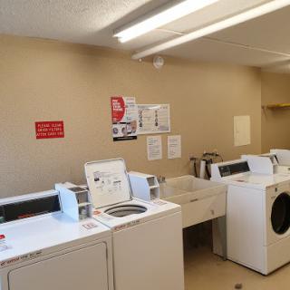 A clean and organized laundry room with washing machines and a drying area.