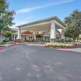 A spacious and welcoming building entrance surrounded by landscaped greenery.