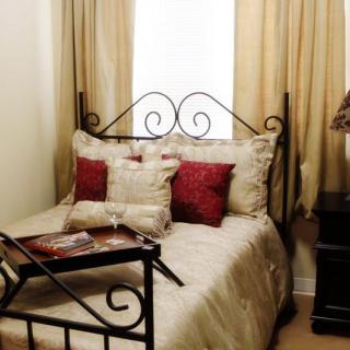 Cozy bedroom with a decorative bed and pillows, featuring a breakfast tray.