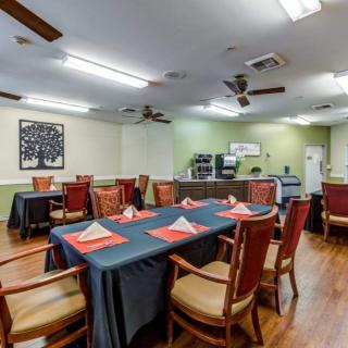 A well-arranged dining area with tables set for a meal, featuring comfortable chairs and tasteful decor.