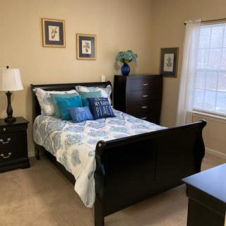 A cozy bedroom with a neatly made bed and stylish decor.
