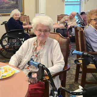 Elderly residents enjoying their meal in a care facility.