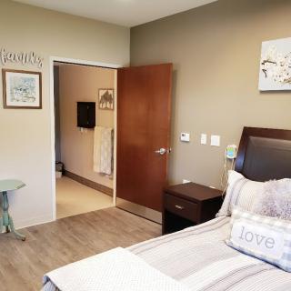 A cozy bedroom with a bed, nightstand, and decorative wall art.