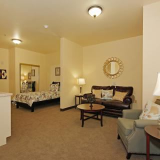 A cozy interior space with a combined living and bedroom area featuring stylish furniture and soft lighting.