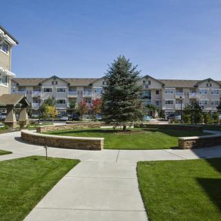 A residential complex with a well-maintained green courtyard and pathways.