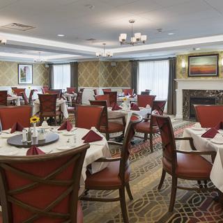 An elegant dining room with neatly arranged tables and chairs, prepared for guests.