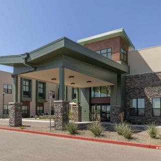 A modern commercial building with a prominent entrance and well-maintained landscaping.