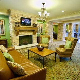 A cozy living room with a fireplace, comfortable seating, and elegant decor.