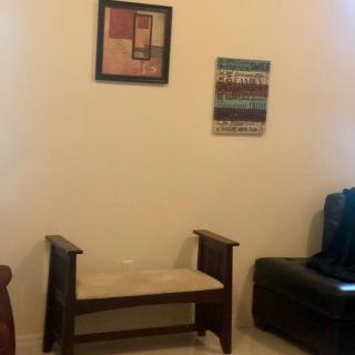 A simple room with a wooden chair and wall art.