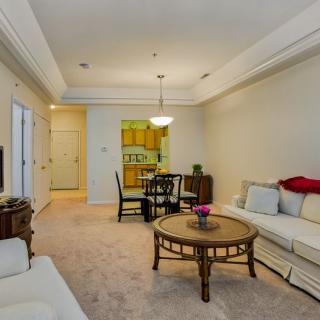 A cozy living room with a comfortable sofa, coffee table, and adjacent dining area.