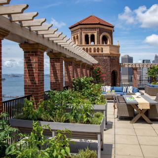 A scenic rooftop garden with outdoor seating and views of the city skyline.