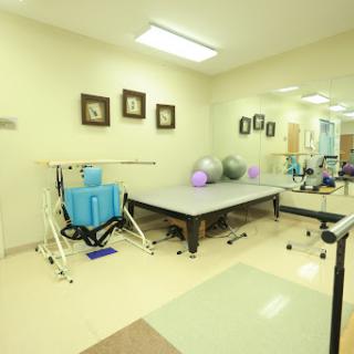 A well-equipped physical therapy room featuring various exercise tools and a therapy table.