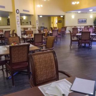 An empty restaurant dining room with neatly arranged tables and chairs.