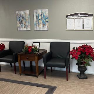A cozy waiting area featuring comfortable chairs, holiday decorations, and colorful artwork on the walls.