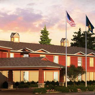 A hotel building exterior with flags at sunset.