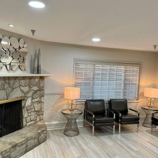 A cozy living room with a stone fireplace and modern seating arrangement.