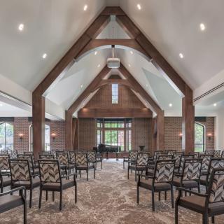 A spacious interior with a high vaulted ceiling and arranged seating.