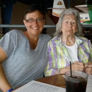 Two people sitting together at a restaurant table, smiling.