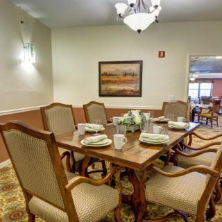 A formal dining room with an elegant table setting and classic wooden chairs.