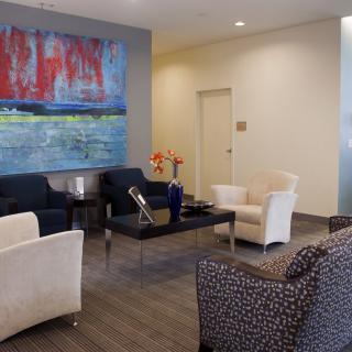 A modern waiting area with comfortable seating and colorful artwork on the wall.