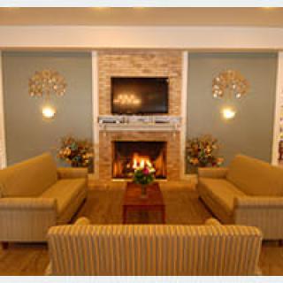 A cozy living room with a fireplace, sofas, and a mounted television.