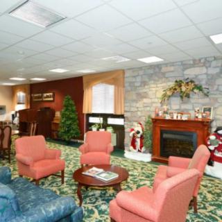 A cozy living room interior with a fireplace, comfortable seating, and festive decorations.
