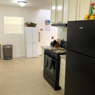 A bright and simple kitchen featuring modern appliances and white cabinetry.