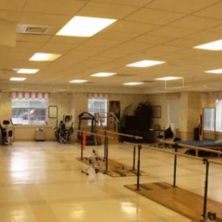 A spacious indoor gym with various exercise equipment and training bars.