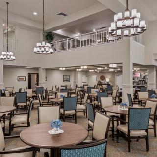 Spacious dining area with elegantly arranged tables and modern lighting fixtures.