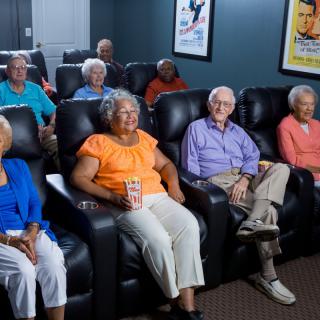 A group of seniors enjoying a movie in a cozy theater setting.