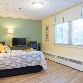 A modern and cozy bedroom with elegant decor and a television.