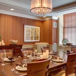 A beautifully set dining room with a modern chandelier and elegant decor.