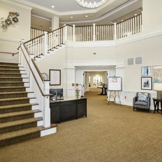 A spacious and well-decorated lobby with a staircase leading to the upper level.