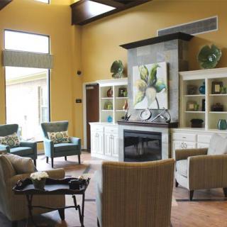 A cozy living room with stylish furniture, a fireplace, and decorative shelving.
